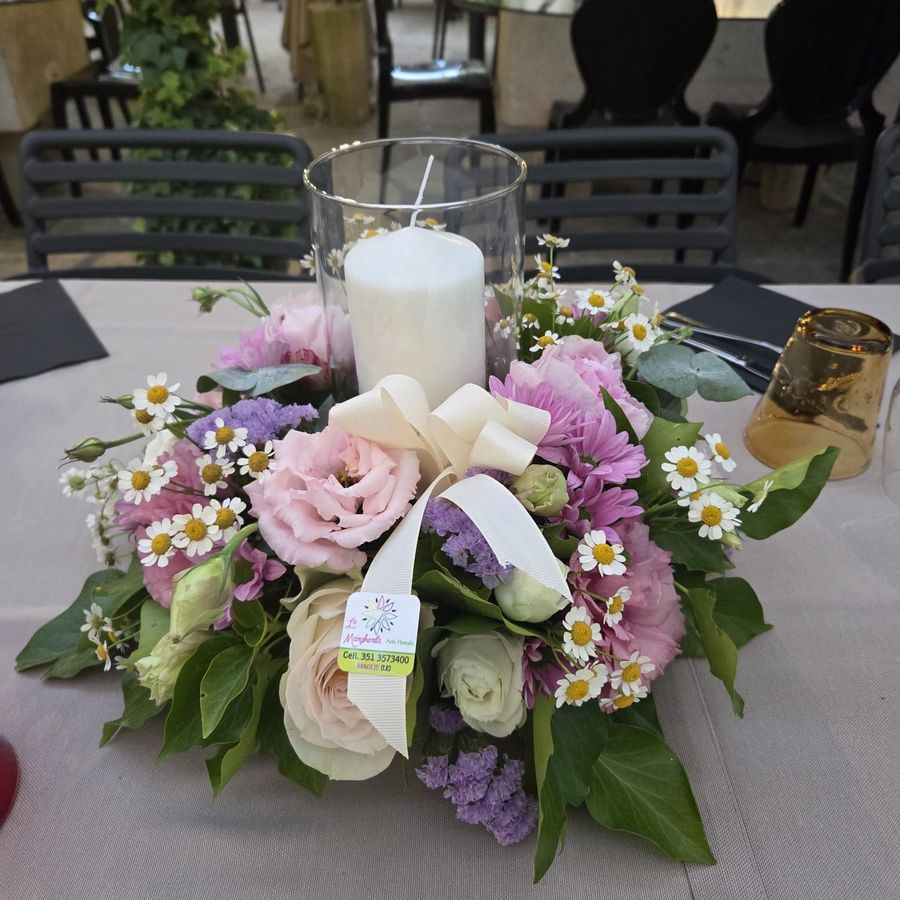 Centrotavola circolare con candela in vaso di vetro, rose, lisianthus rosa, crisantemi lilla e camomilla